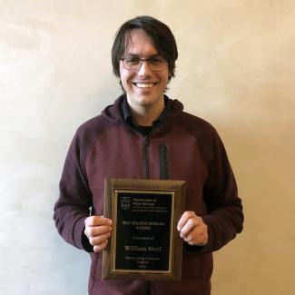 Bill Ricci posing with Wilbur Duncan Award plaque - 2019