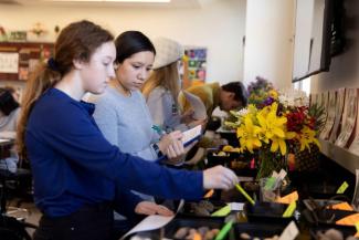 Undergraduate Sarah Miller and Pamela Pedroza look through different plant varieties during a plant biology reproduction laboratory class.