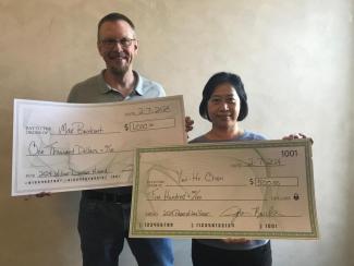 Dr. Burke and Dr. Tsai holding large checks