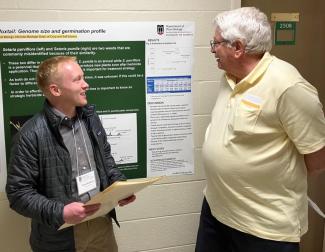 A student and professor discussing the student's research poster