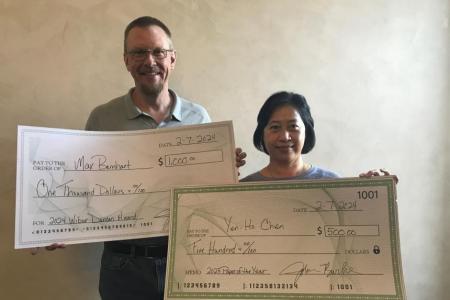 Dr. Burke and Dr. Tsai holding large checks